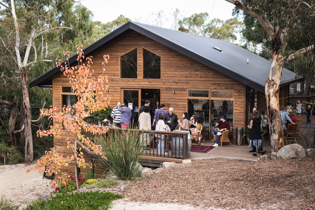 People drinking wine outside of a cabin 